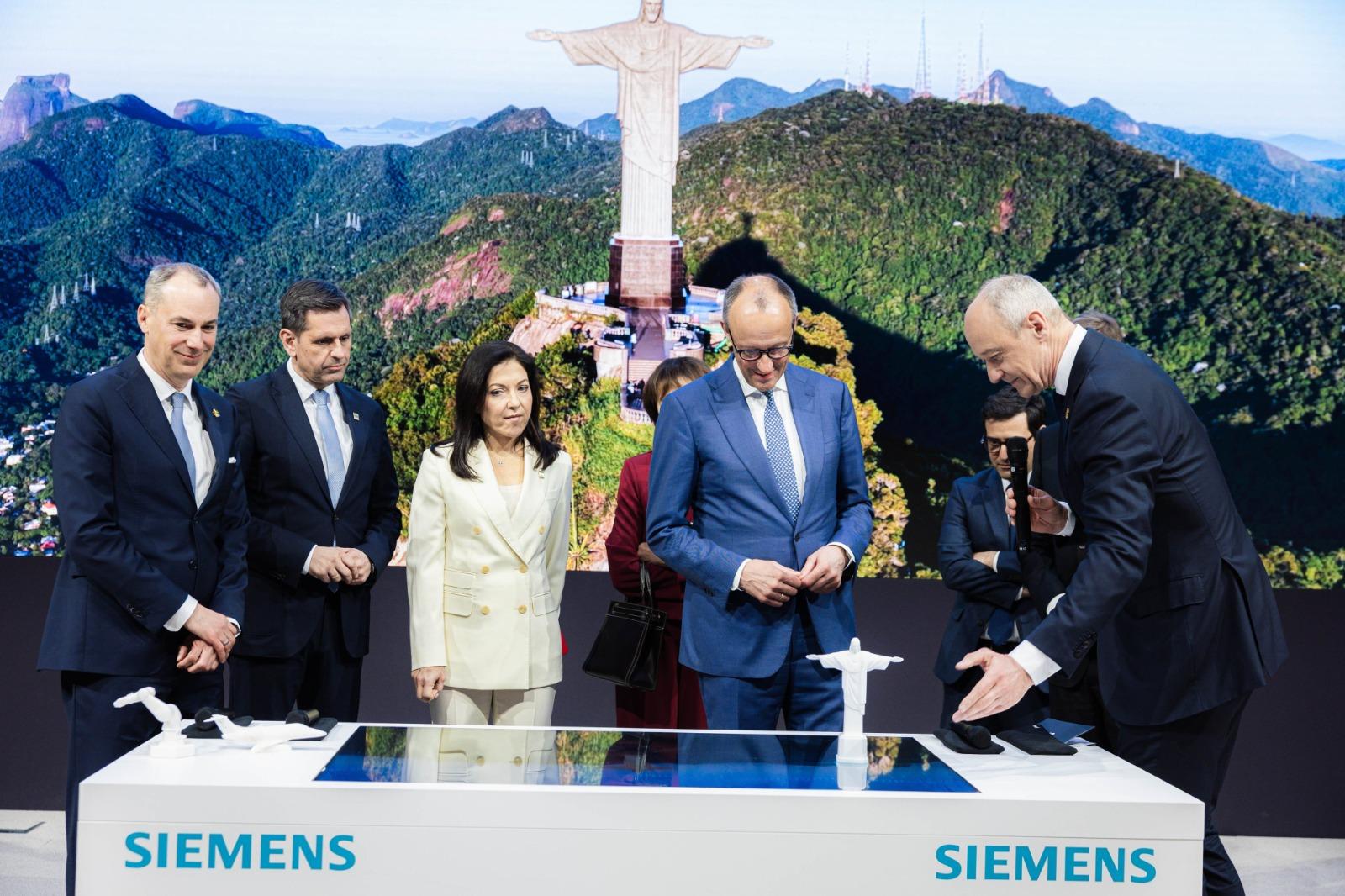 Com chanceler alemão no palco, Siemens homenageia Brasil com imagem do Cristo Redentor para demonstrar Inteligência Artificial Industrial na Hannover Messe 2026